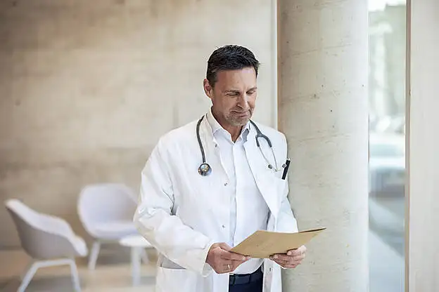 Smiling doctor with report document in hospital